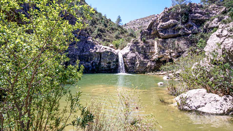 Front view of waterfall of Gorg del salt (swimming-hole) in El Barranc de la Encantada